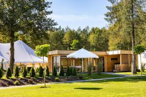 ein Haus mit einem weißen Sonnenschirm im Gras in der Unterkunft Hotel Boginia in Boginia