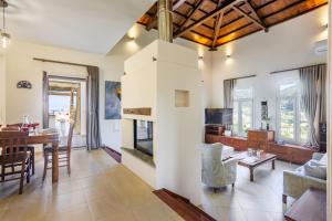 a living room and dining room with a fireplace at Villa Anatoli in Skopelos Town