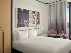 a hotel room with a white bed and a window at The William Vale in Brooklyn