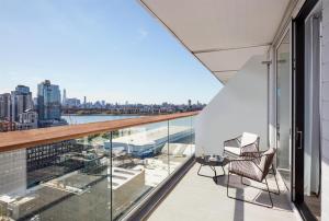a balcony with two chairs and a view of the city at The William Vale in Brooklyn +131 photos