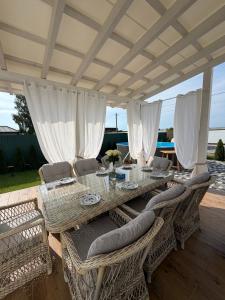 a dining table and chairs under a patio umbrella at Villa Menorca in Chornomorsk