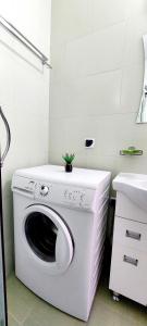 a washing machine in a bathroom next to a sink at Апартамент ШАХОВ in Tŭnkovo