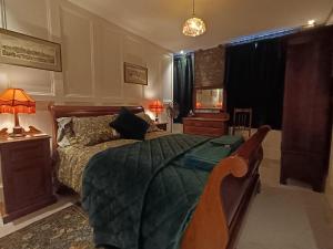 a bedroom with a bed with a green comforter at The Vicar's View at the Old Vicarage in Lincoln