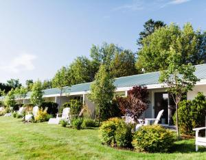 a house with a yard with chairs and trees at Yachtsman Lodge & Marina in Kennebunkport