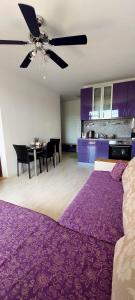 a living room with a purple bed and a table at Апартамент ШАХОВ in Tŭnkovo