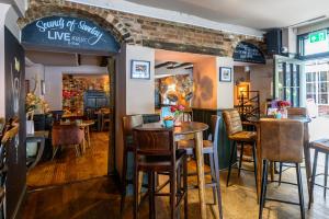a restaurant with tables and chairs and a brick wall at The Loopy Shrew in Shrewsbury