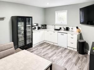a kitchen with white cabinets and a black refrigerator at The Stables in Market Rasen