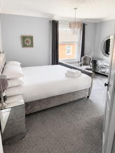a bedroom with a large white bed and a window at The Stables in Market Rasen +3 photos