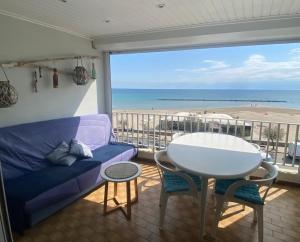 a living room with a couch and a table and a view of the beach at SUPERBE VUE sur la MER in Le Grau-dʼAgde