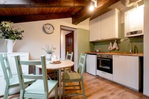 a kitchen with a table and chairs and a clock at Una mansarda in montagna in Fanano
