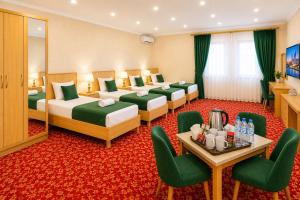 a hotel room with four beds and a table and chairs at Sultanahmet Hotel in Baku