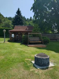 a park with a bench and a tree stump in the grass at Figura in Zdíkov