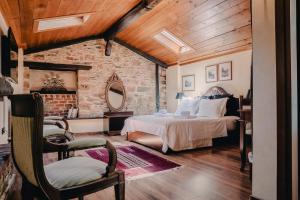 a bedroom with a bed and a brick wall at Palea Poli Boutique Hotel in Naousa