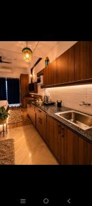 a kitchen with wooden cabinets and a sink at Aashirwad Retreat in Greater Noida
