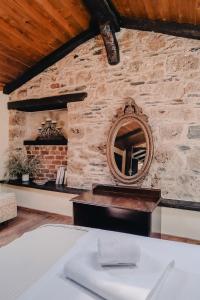 a room with a stone wall with a mirror at Palea Poli Boutique Hotel in Naousa
