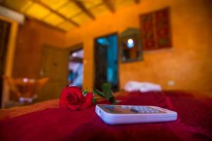 a remote control sitting on top of a bed with a rose at Kasbah Imlil in Imlil +2 photos