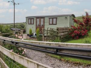 a tiny house on the side of a track at The Herdsman Luxury Shepherds Hut in Barnoldswick