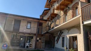 a building with balconies and a chair on a street at El Torch di Long Elisa in San Garmano Chisone