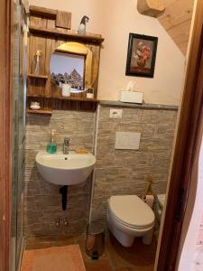 a bathroom with a sink and a toilet and a mirror at El Torch di Long Elisa in San Garmano Chisone