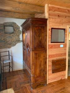 a large wooden cabinet in the corner of a room at El Torch di Long Elisa in San Garmano Chisone