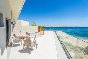 a balcony with chairs and a table and the ocean at enplomare in Plomari