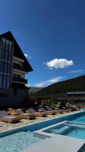 a row of lounge chairs next to a swimming pool at Poarta Raiului in Tău Bistra