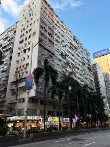 a large building with palm trees in front of it at Sleep Inn in Hong Kong