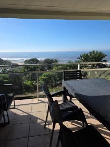 a table and chairs on a patio with a view of the ocean at Unit 9 The Beachfront in Ramsgate
