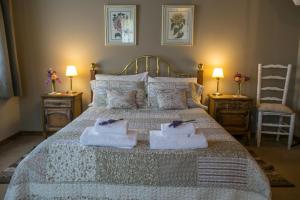 Un dormitorio con una cama con toallas. en El lugar de la Flor, en San Carlos de Bariloche