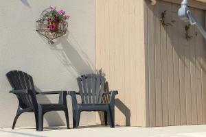 two chairs sitting next to a wall with a basket of flowers at Lôu cayrou in Beaumarches +25 photos