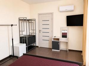 a room with a room with a door and a tv at Qzone 2 in Chornomorsk