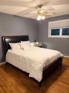 a bedroom with a large bed with a ceiling fan at Urban Midtown Stays in St. John's +8 photos