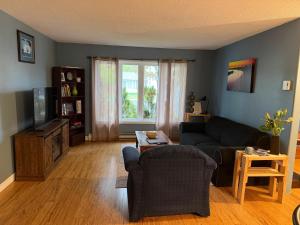 a living room with a couch and a tv at Urban Midtown Stays in St. John's