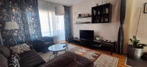 a living room with a couch and a table at Sunny Central Apartment in Sofia