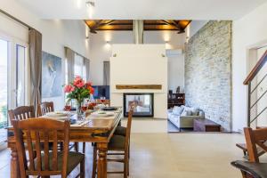 a dining room with a table and a fireplace at Villa Anatoli in Skopelos Town