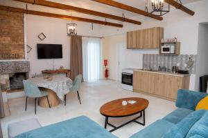 a living room with a couch and a table and a kitchen at Linovrochi holiday house with private pool in Lefkandi Chalkidas