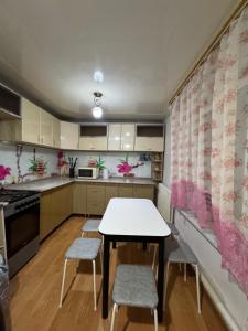a kitchen with a table and chairs in a room at House on the mountain in Ustʼ-Kamenogorsk