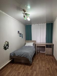 a bedroom with a bed and a desk at House on the mountain in Ustʼ-Kamenogorsk +11 photos