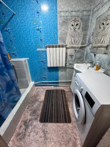 a blue bathroom with a washer and a sink at House on the mountain in Ustʼ-Kamenogorsk