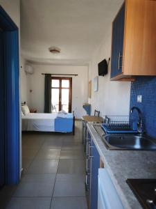 a kitchen with a sink and a bed in a room at Ammoudia Studios in Agiassos