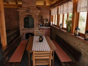 a dining room with a table and a fireplace at Vikendica Jagodica in Ivanjica