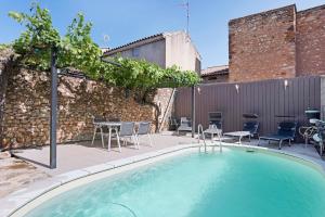 a swimming pool with chairs and a table at Le Clos Mazerolles in Cruzy