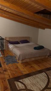 a bed in a bedroom with a wooden floor at Mirzahouse in Tbilisi City