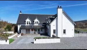 a white house with a black roof at Daviot Lodge in Inverness