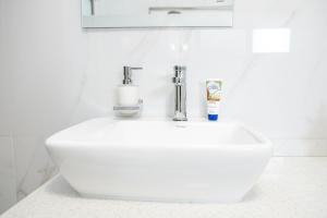 a white sink in a white bathroom at Millenium Heights Borrowdale in Harare +13 photos