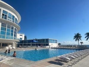a large swimming pool in front of a building at Castle Beach Resort Condo - Panoramic Large Penthouse or Deluxe 1 BR Direct Ocean View and beach access- Updated-Free parking- in Miami Beach