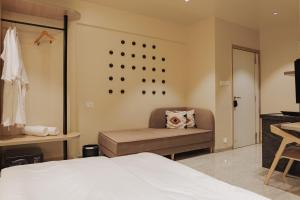 a bedroom with a bed and a couch and a mirror at Abhibha Suites Waterfront in Pune