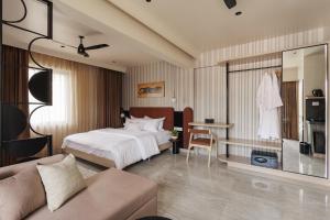 a hotel room with a bed and a couch at Abhibha Suites Waterfront in Pune