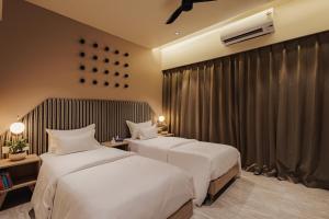 a hotel room with two beds and a window at Abhibha Suites Waterfront in Pune +44 photos