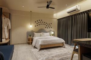 a bedroom with a large bed and a ceiling fan at Abhibha Suites Waterfront in Pune